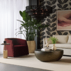 Burgundy Serenade Lounge Chair styled beside a modern side table and oversized indoor plant.